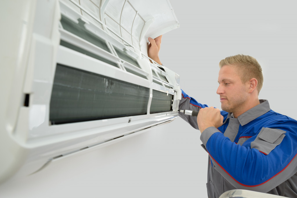 Portrait Of Young Male Technician Repairing Air Conditioner