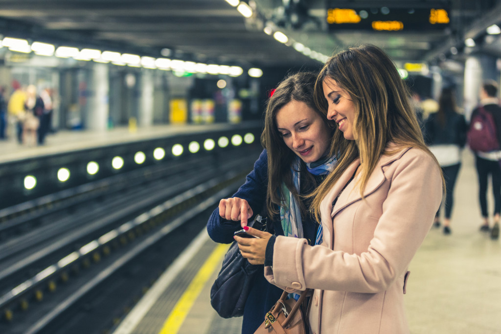 tourists looking at a phone while waiting on train