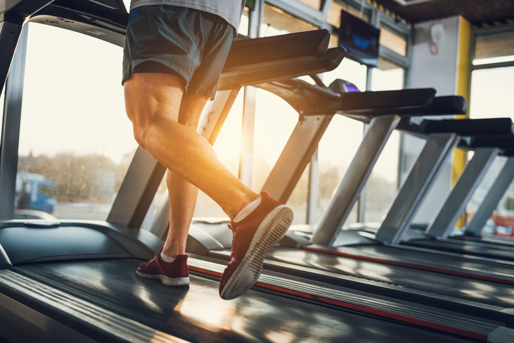 A man running on a treadmill in a gym