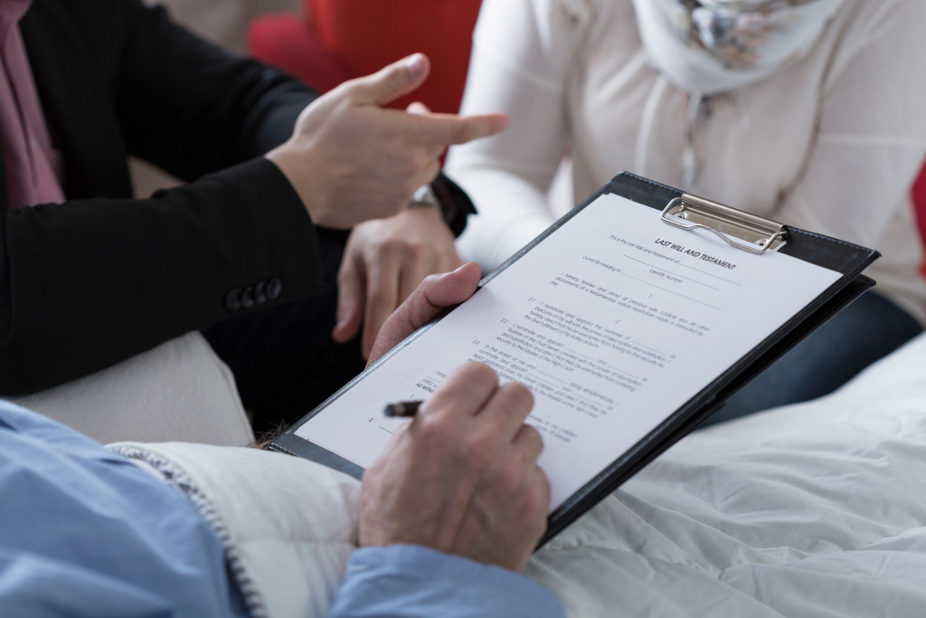 Close-up of older sick man holding his last will and testament