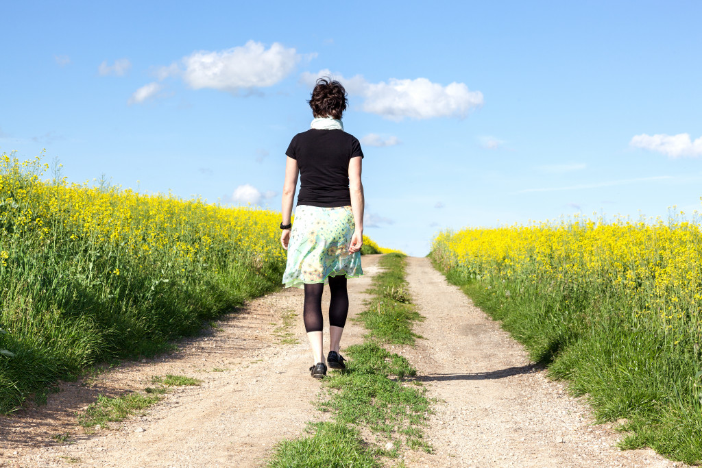 Young woman walking along a path in nature.