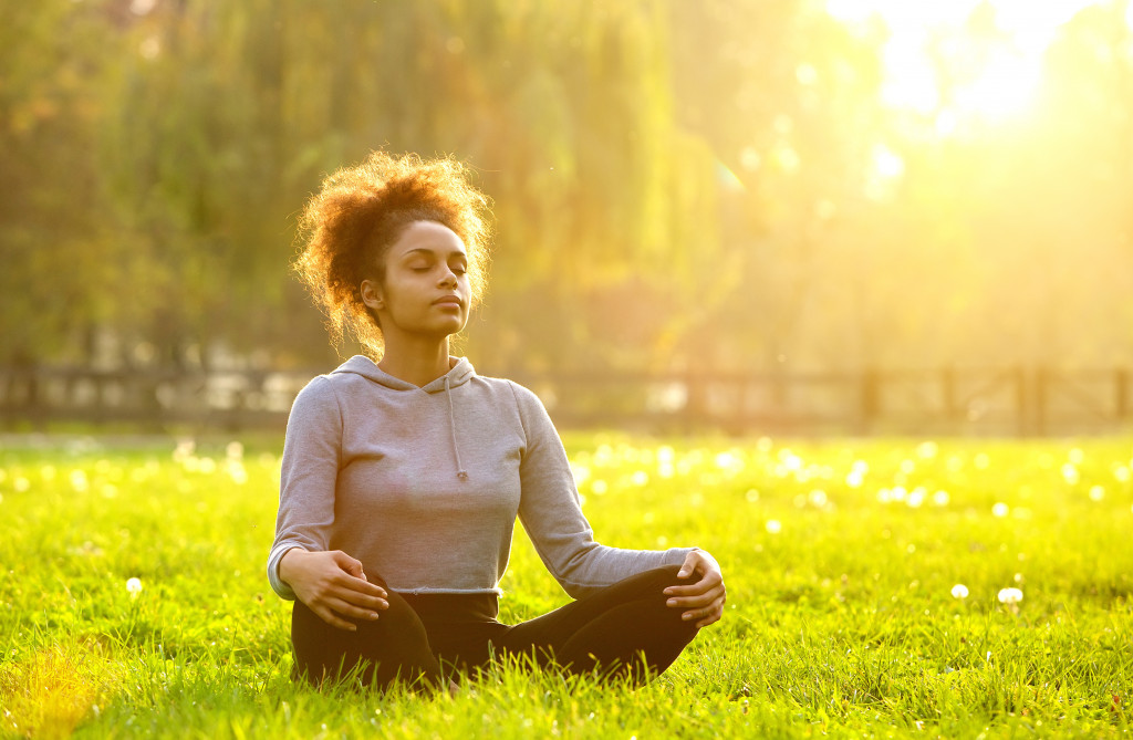 Young woman meditating in a park.