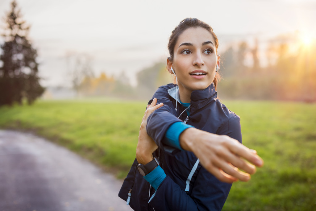 A woman stretching before running in the park