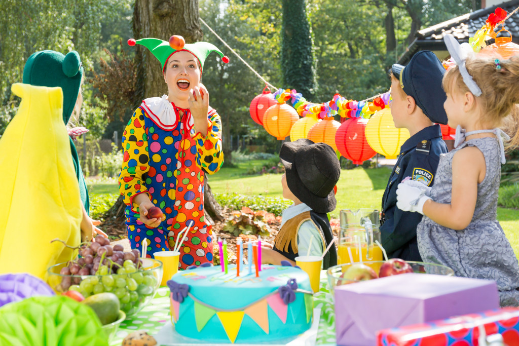 Children's outdoor party with a clown and colorful decorations.