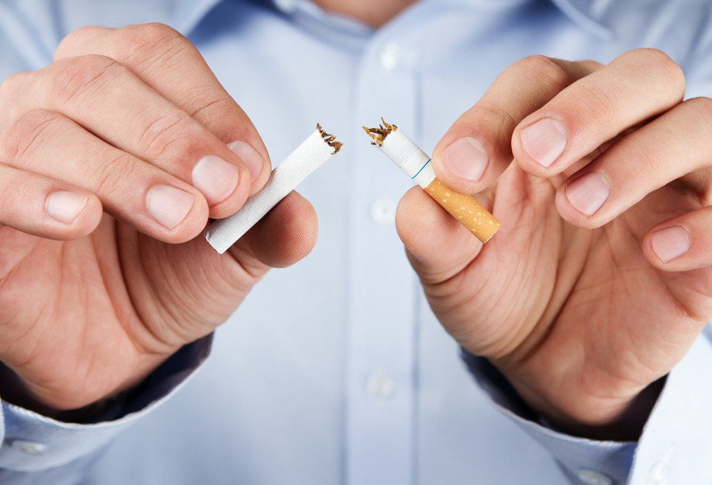 A man breaking a single cigarette stick